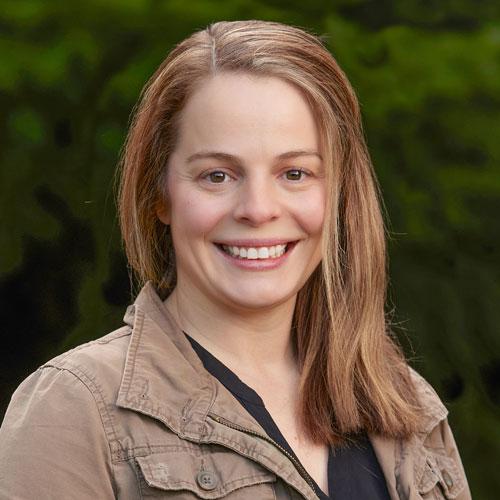 Headshot of woman with brown hair and a brown shirt