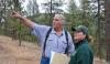 two people in a forest, one is pointing