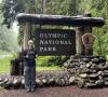 Ashlee standing in front of the sign for Olympic National Park.